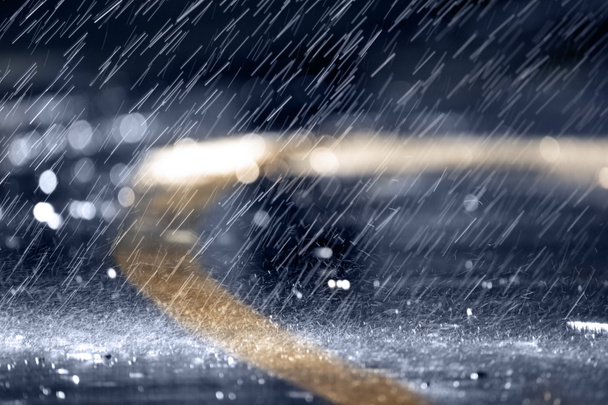 Сильний дощ або падіння, дощі падають на асфальт, вночі або ввечері
. - Фото, зображення