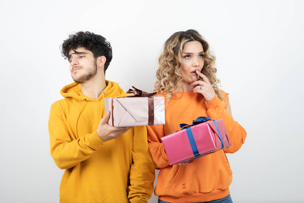 Portrait of young good-looking couple holding early holiday presents. High quality photo - Photo, Image