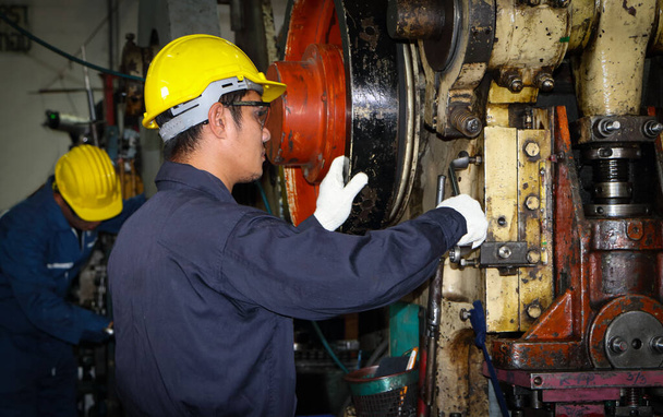 Trabalhador masculino asiático Em indústrias que usam óculos, chapéus de segurança e uniformes de segurança Suporte de ferramenta chave Suporte técnico de manutenção da máquina Conceito de operação Em uma fábrica industrial com confiança - Foto, Imagem