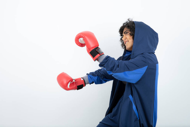 Imagen de la morena rizada boxeadora femenina en guantes rojos haciendo ejercicio. Foto de alta calidad - Foto, Imagen