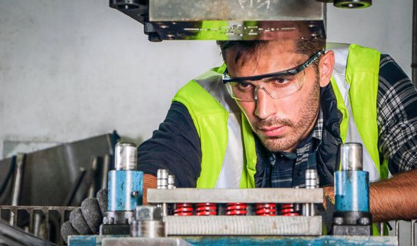 Portrait of a professional male engineer Wears safety uniforms and glasses. Maintenance and setup of machines In industrial factories producing metal parts with confidence Concept of engineering work - Photo, image