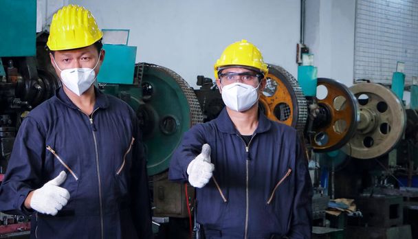 COVID 19に対して保護マスクを着用する男性労働者、 COVIDの普及を防止するという概念、または作業中のCOVID 。産業機械の整備及び設置 - 写真・画像