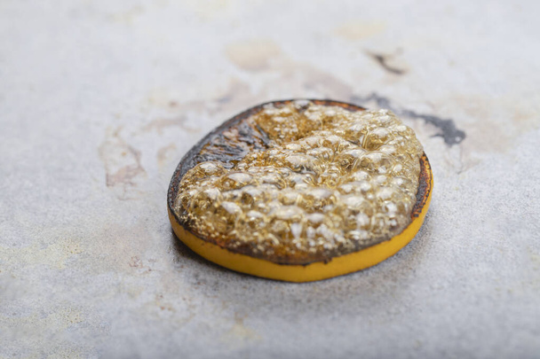 Fried slice of lemon isolated on a stone background. High quality photo - Photo, Image