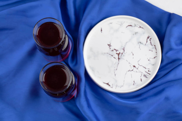 Üres tányér, kék asztalterítőre helyezett üvegpohár borral. Kiváló minőségű fénykép - Fotó, kép