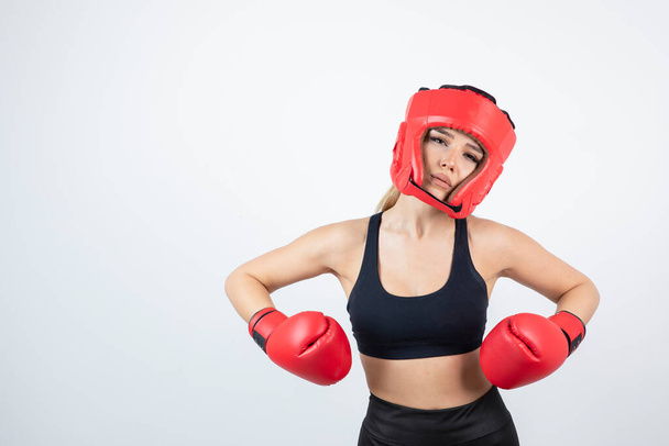 赤い手袋とヘルメットの訓練で若い女性ボクサーの肖像画。高品質の写真 - 写真・画像