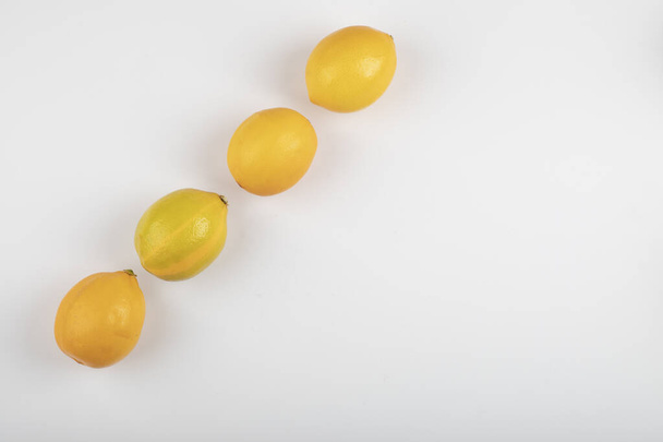 Tuoreet keltaiset sitruunat valkoisella pohjalla. Laadukas kuva - Valokuva, kuva