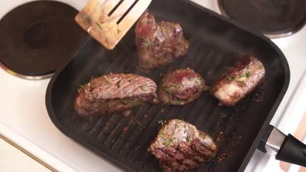 A steak öntöttvas serpenyőben történő elkészítésének folyamata. A szakács húsos ételt készít.. - Felvétel, videó