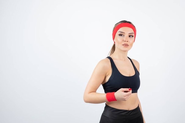 Portret van een jonge atletische vrouw met een rode hoofdband. Hoge kwaliteit foto - Foto, afbeelding