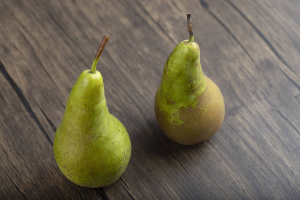 Dos deliciosas peras verdes maduras sobre fondo de madera. Foto de alta calidad - Foto, Imagen