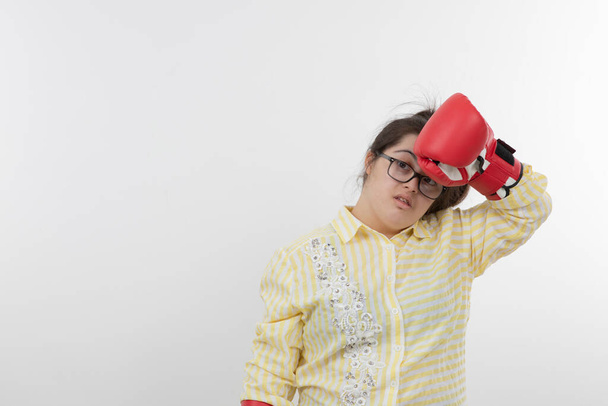 Image of young girl with a Down syndrome wearing boxing gloves . High quality photo - Zdjęcie, obraz