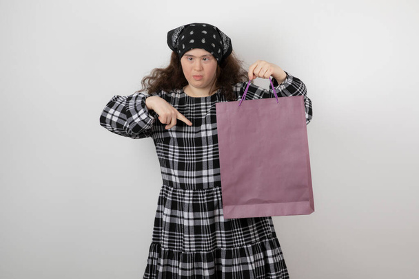 Αξιολάτρευτο κορίτσι με σύνδρομο Down που κρατάει τσάντα για ψώνια. Υψηλής ποιότητας φωτογραφία - Φωτογραφία, εικόνα