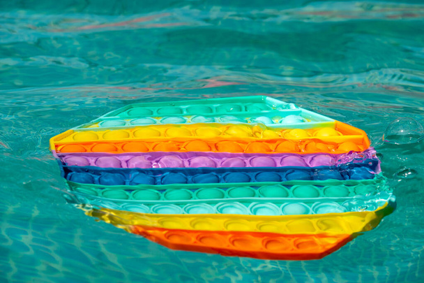 Helles Regenbogenspielzeug Antistress für Kinder und Erwachsene auf buntem Hintergrund. - Foto, Bild