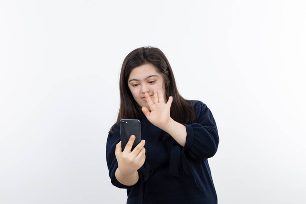 Портрет красивої дівчини з синдромом Дауна, що тримає мобільний телефон. Високоякісна фотографія
 - Фото, зображення