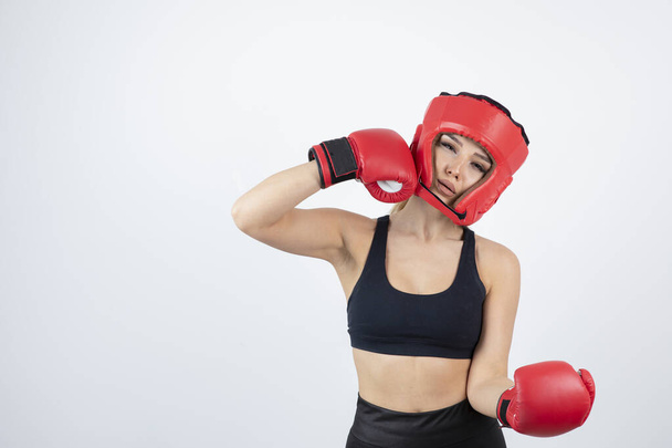 Kép fiatal női bokszolóról piros kesztyűben és sisak harcban. Kiváló minőségű fénykép - Fotó, kép