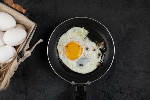 Výborná snídaně se slunečnými bočními smaženými vejci na pánvi a koši s vejci. Kvalitní fotografie - Fotografie, Obrázek