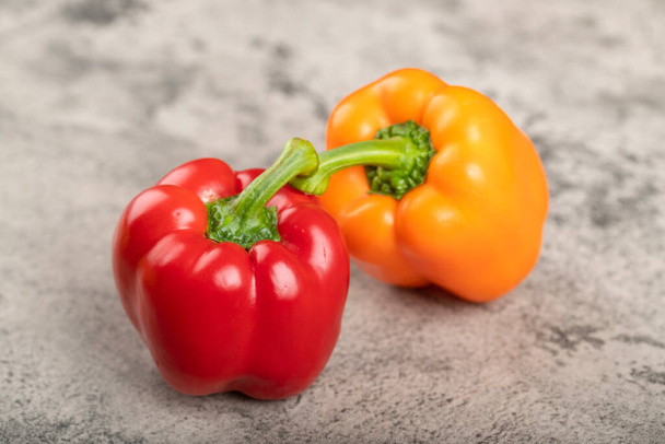 Two colorful sweet bell peppers on stone background. High quality photo - Zdjęcie, obraz