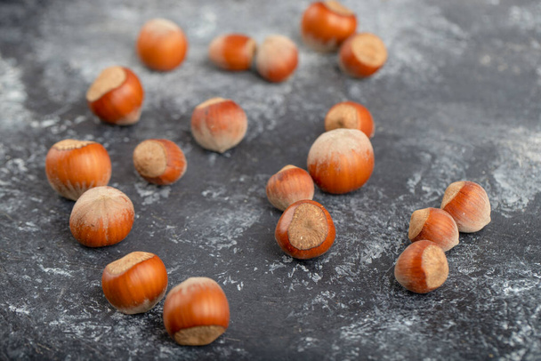Healthy hazelnuts in shell placed on stone table . High quality photo - Fotografie, Obrázek