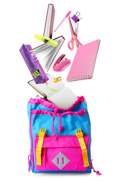 School backpack with flying stationery on white background - Photo, Image