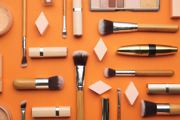 Decorative cosmetics and makeup brushes on color background - Photo, Image