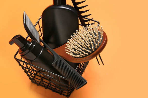 Basket with hair brush, combs and cosmetics on color background - Photo, Image
