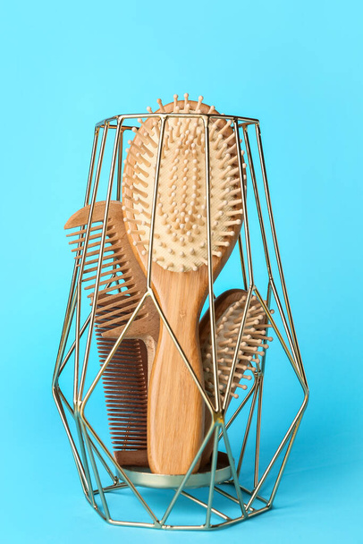 Candle holder with hair brushes and combs on color background - 写真・画像