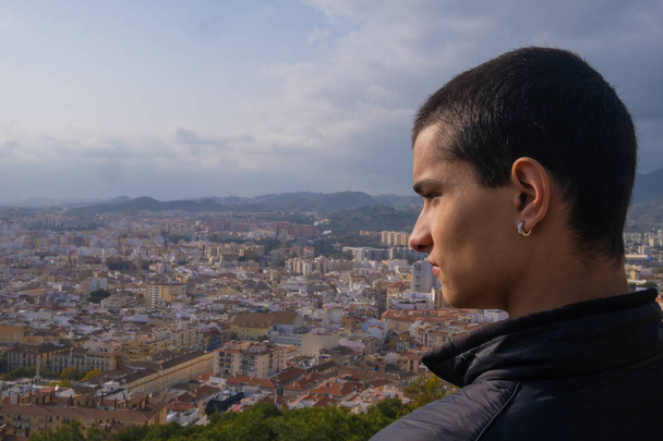 Νεαρό αγόρι κοιτάζει πλάγια στην πόλη της Μάλαγα στην Ισπανία. - Φωτογραφία, εικόνα