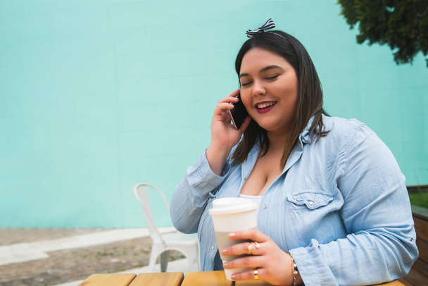 Young plus size woman talking on the phone. - 写真・画像