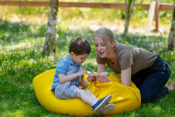 mamá enseña a pronunciar palabras usando la técnica Doman para un niño autista en el patio - Foto, Imagen