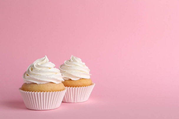 Delicious cupcakes with white cream on pink background. Space for text - Photo, image