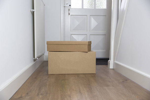 Stack of Cardboard boxes blank in the Hallway of new home on the floor. Moving, storage or delivery concept. Copy space - Photo, Image