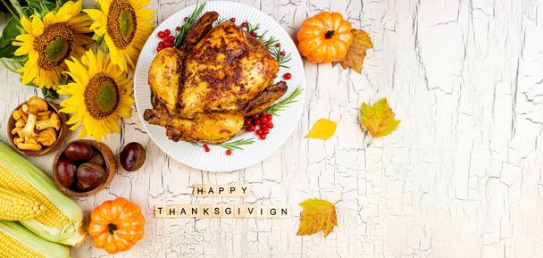 Cooked chicken for Thanksgiving Day. Roasted whole chicken or turkey with autumnal vegetables and fruits for thanksgiving on wooden table. Banner format with copy space - Photo, Image