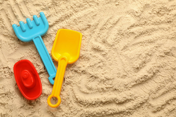 Flat lay of beach toy kit on sand, space for text. Outdoor play - Фото, изображение