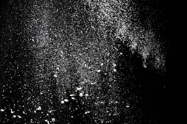Έκρηξη σκόνης. Πιτσιλιές λευκής σκόνης που απομονώνονται σε μαύρο φόντο. Αλεύρι κοσκινισμένο σε σκούρο φόντο. Εκρηκτική σκόνη λευκή - Φωτογραφία, εικόνα