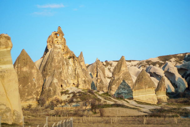 View of the ancient rocks houses in the valley during the sunset in Cappadocia, Turkey - Foto, afbeelding