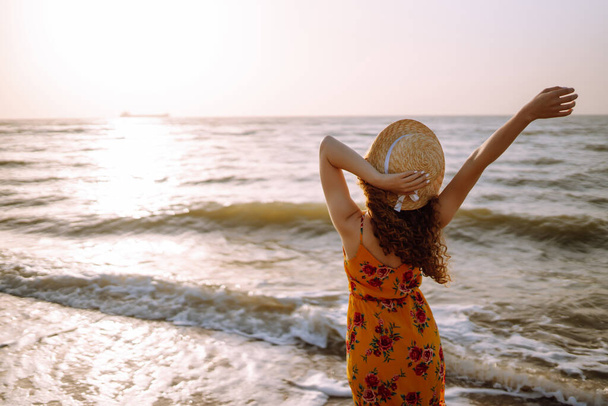 Fiatal nő élvezi a gyönyörű naplemente, nyugodt óceán természet utazás közben. Nyáron. Utazás, hétvége, pihenés és életmód koncepció. - Fotó, kép