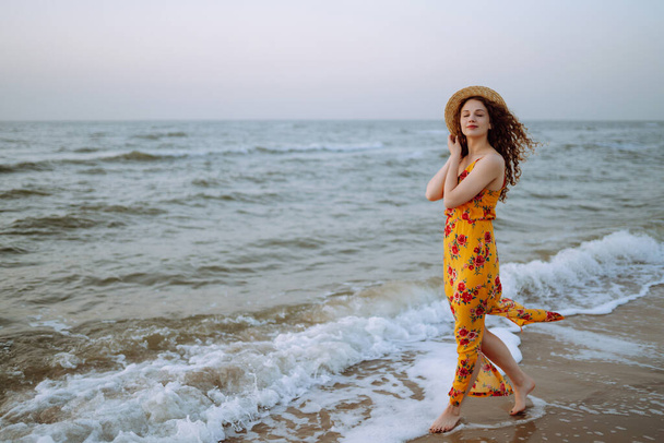 Young woman enjoying beautiful sunset, serene ocean nature during travel holidays. Summer time. Travel, weekend, relax .and lifestyle concept. - 写真・画像