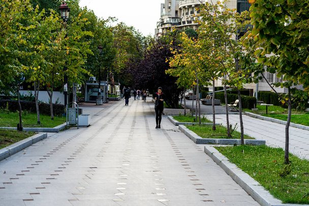 Άνθρωποι μετακινούνται, πεζοί περπατούν στην περιοχή του κέντρου του Βουκουρεστίου, Ρουμανία, 2021 - Φωτογραφία, εικόνα