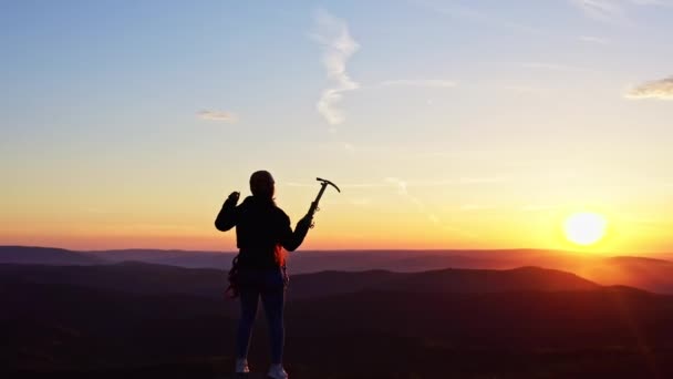 Dolly zoom effect van een vrouw gelukkig steekt haar handen op de top van een berg bij zonsondergang. - Video