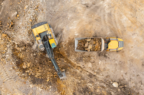 Excavadora industrial pesada cava el suelo y lo transfiere al camión. - Foto, imagen