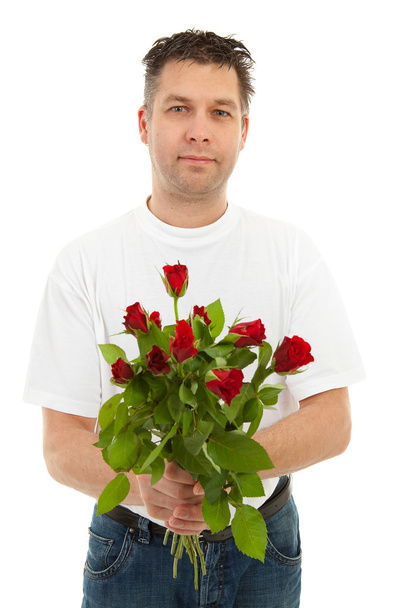 Handsome man is giving bouquet of roses, isolated on white background - 写真・画像