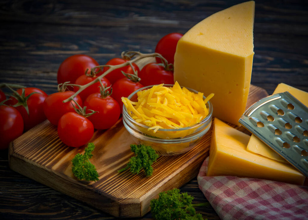 geriebener Käse, Petersilie auf Holzgrund - Foto, Bild