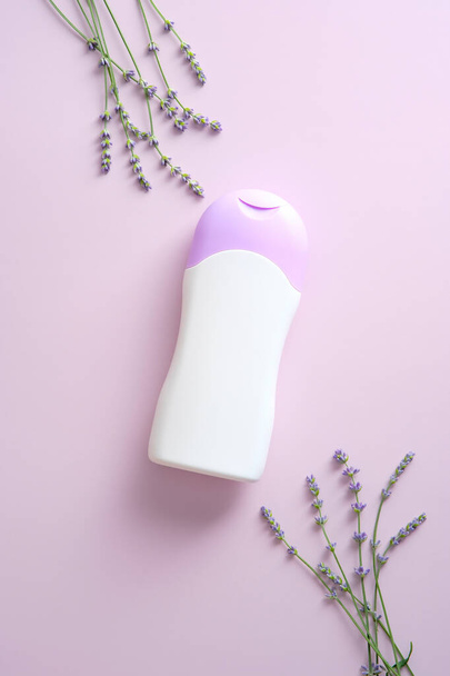 Natural skincare product bottle mockup with lavender on purple background. Flat lay, top view. Herbal beauty product container design. - Photo, Image