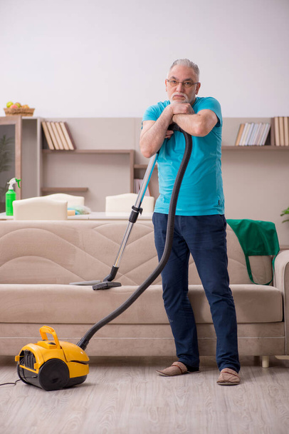 Yaşlı adam evi temizliyor. - Fotoğraf, Görsel