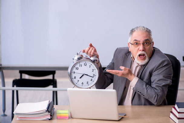 Oude mannelijke leraar voor whiteboard in time management conce - Foto, afbeelding