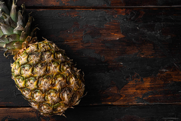 Tasty whole pineapple set, on old dark  wooden table background, top view flat lay, with copy space for text - Фото, зображення
