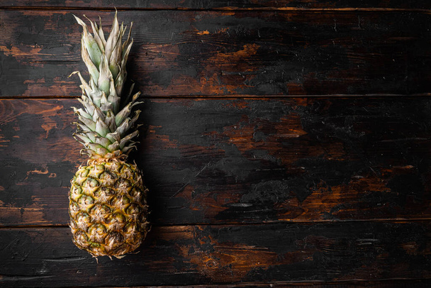 Pineapple tropical fruit set, on old dark  wooden table background, top view flat lay, with copy space for text - 写真・画像