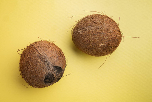 Ensemble de noix de coco, sur fond jaune texturé d'été, vue de dessus à plat, avec espace de copie pour le texte - Photo, image