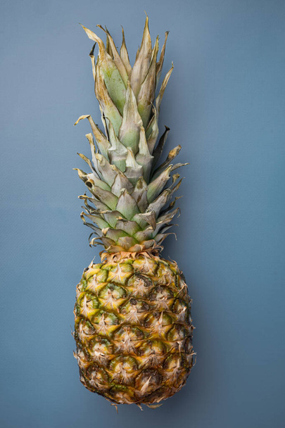 Гавайський ананас, на синьому текстурованому літньому фоні, був плоским. - Фото, зображення