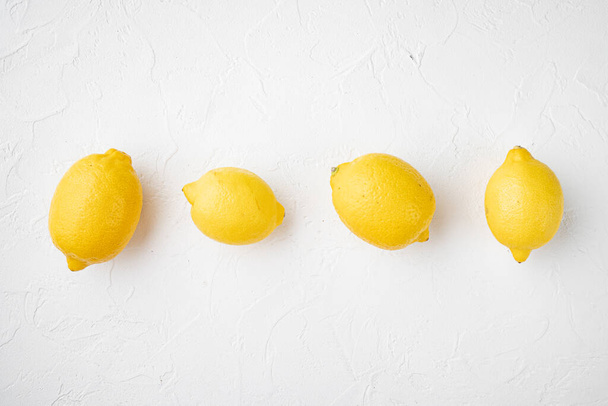 Whole ripe lemon set, on white stone table background, with copy space for text - Foto, Bild