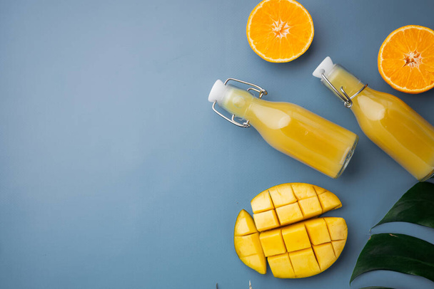 Tropické ovoce, ananas, mango a pomeranče set, na modrém texturovaném letním pozadí, horní pohled plochý ležel, s kopírovacím prostorem pro text - Fotografie, Obrázek